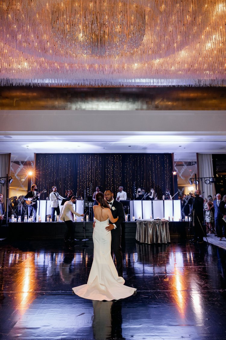 A couple dancing at their wedding reception with a live band